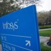 An employee walks past a signage board in the Infosys campus at the Electronics City IT district in Bangalore, February 28, 2012. REUTERS/Vivek Prakash/File Photo
