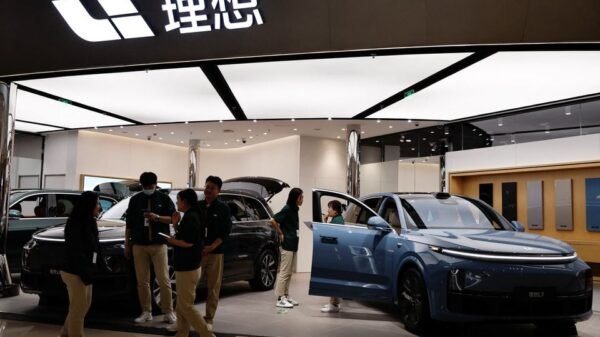 Staff members stand at the booth of Chinese electric vehicle (EV) maker Li Auto, at a shopping mall in Beijing, China November 3, 2023. REUTERS/Tingshu Wang/File Photo